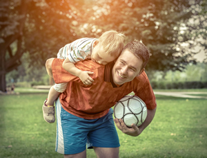 man playing soccer with young boy